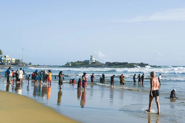Kerala, Hindistan - 08 Eylül 2019: Kovalam plajı ve Vizhinjam deniz feneri. İnsanlar Trivandrum 'da deniz kıyısında eğleniyor..