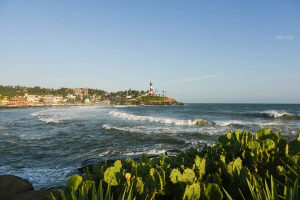 Kerala, Hindistan - 08 Eylül 2019: Kovalam plajı ve Vizhinjam deniz feneri. Deniz dalgaları kıyıya doğru ilerliyor..