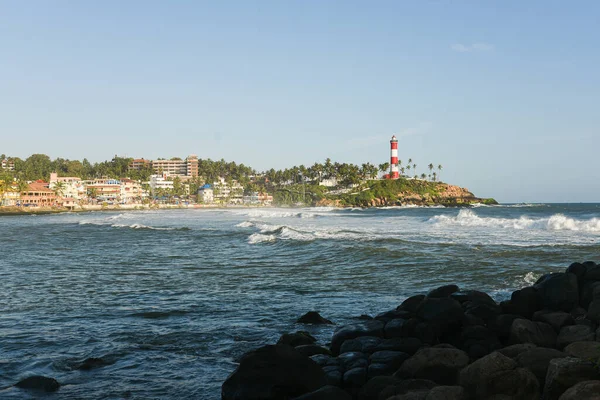 Kerala, Hindistan - 08 Eylül 2019: Kovalam plajı ve Vizhinjam deniz feneri. Deniz dalgaları kıyıya doğru ilerliyor..