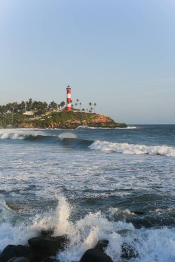 Kerala, Hindistan - 08 Eylül 2019: Kovalam plajı ve Vizhinjam deniz feneri. Deniz dalgaları kıyıya doğru ilerliyor..