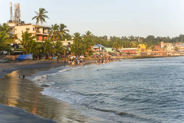Kerala, Hindistan - 08 Eylül 2019: Kovalam plajı ve Vizhinjam deniz feneri. İnsanlar Trivandrum 'da deniz kıyısında eğleniyor..