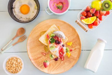 Kızarmış ekmek ve meyveli yoğurt, çırpılmış yumurta ve ahşap manzaralı tava..
