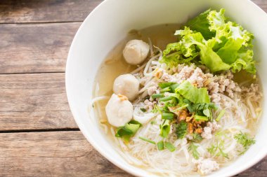 Domuz etli erişte ve ahşap üzerinde sebze.