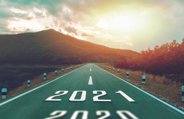 2021 numaralı karayolunda yüksek dağlar ve hedefe giden parlak güneş ışığı var. Yeni Yıl Konsepti 2021