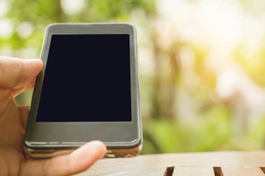 Gün batımı arkaplanlı telefon fotokopi alanını tutan elleri kapat.