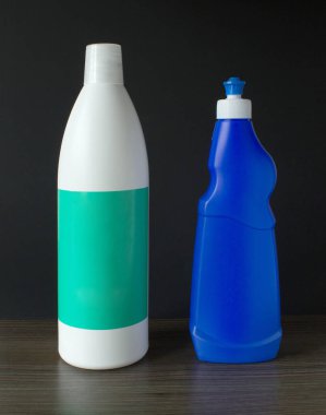 Arka planda iki plastik şişe, kaplar, sabun, kozmetik, bakım sıvısı.