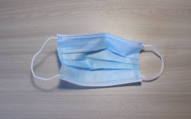 Kullanılmış tıbbi maske, mavi, masanın üstünde.