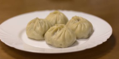 Tabakta Buryat buzy. Buryat ulusal yemeği. Bir tabak hamur ve et. Orta odak, bulanık kenarlıklar.