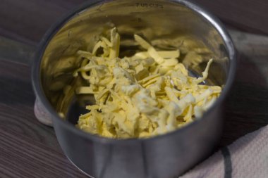 Tencerede ızgara tereyağı. Mutfağın içi, bir havlu, çizgili, bulanık arka plan..