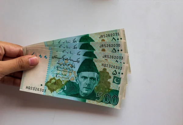 Pakistan 500 Note elinde, beyaz arka planda izole edilmiş.