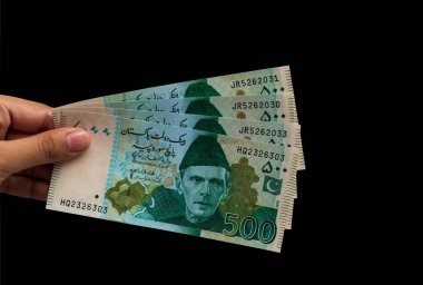 Pakistan 500 Note elinde, siyah arka planda izole edilmiş.