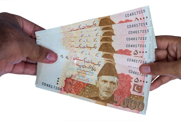 Pakistan 5000 Note elinde, beyaz arka planda izole edilmiş.