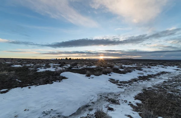 Solnedgång tid över fält efter snö — Stockfoto