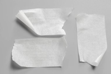 Ve beyaz viski kasetler gri arka plan üzerinde ayarlayın. Yatay ve farklı boyut beyaz yapışkan bant, yapıştırıcı parçaları yırtılmış.