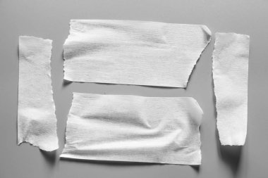 Ve beyaz viski kasetler gri arka plan üzerinde ayarlayın. Yatay ve farklı boyut beyaz yapışkan bant, yapıştırıcı parçaları yırtılmış.