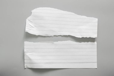 Gri arka planda beyaz yırtık kağıt. koleksiyon kağıdı yırtılması