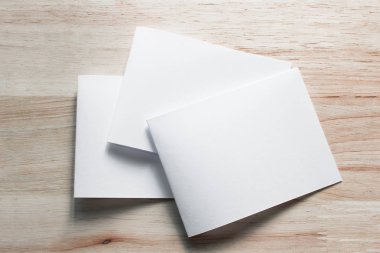 Boş portre mock-up kağıt. Broşür dergi izole kahverengi ahşap masa, değiştirilebilir arka plan / beyaz kağıt ağaç izole