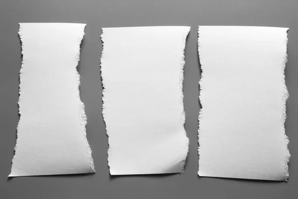 白色撕破的纸灰色背景 收集纸屑 — 图库照片