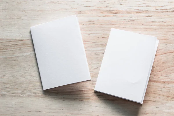 Boş portre mock-up kağıt. Broşür dergi izole kahverengi ahşap masa, değiştirilebilir arka plan / beyaz kağıt ağaç izole