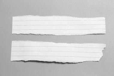 Gri arka planda beyaz yırtık kağıt. koleksiyon kağıdı yırtılması