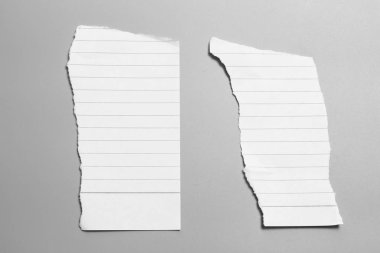 Gri arka planda beyaz yırtık kağıt. koleksiyon kağıdı yırtılması