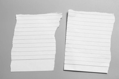 Gri arka planda beyaz yırtık kağıt. koleksiyon kağıdı yırtılması