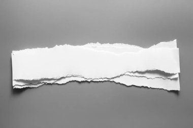 Gri arka planda beyaz yırtık kağıt. koleksiyon kağıdı yırtılması