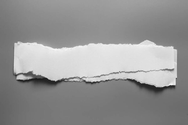 Белая порванная бумага на сером фоне. коллекционный разрыв бумаги