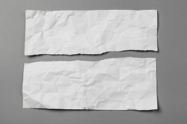 Gri arka planda beyaz yırtık kağıt. koleksiyon kağıdı yırtılması