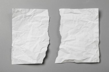 Gri arka planda beyaz yırtık kağıt. koleksiyon kağıdı yırtılması