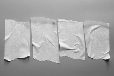 Ve beyaz viski kasetler gri arka plan üzerinde ayarlayın. Yatay ve farklı boyut beyaz yapışkan bant, yapıştırıcı parçaları yırtılmış.