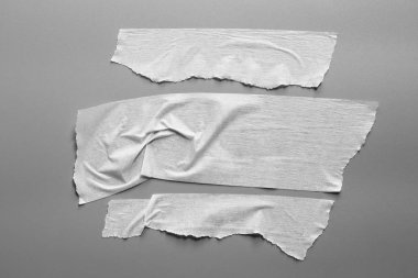 Ve beyaz viski kasetler gri arka plan üzerinde ayarlayın. Yatay ve farklı boyut beyaz yapışkan bant, yapıştırıcı parçaları yırtılmış.