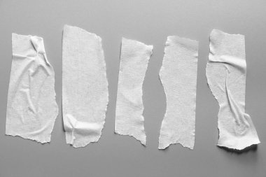 Ve beyaz viski kasetler gri arka plan üzerinde ayarlayın. Yatay ve farklı boyut beyaz yapışkan bant, yapıştırıcı parçaları yırtılmış.