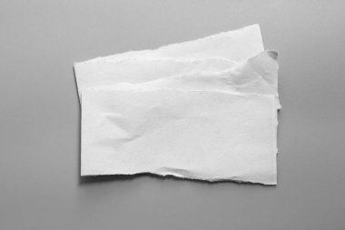 Gri arka planda beyaz yırtık kağıt. koleksiyon kağıdı yırtılması