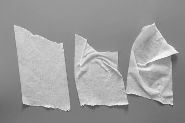 Gri arka plan üzerinde beyaz teyp kümesi. Yatay ve farklı boyut siyah bant, yapıştırıcı parçaları yırtılmış.