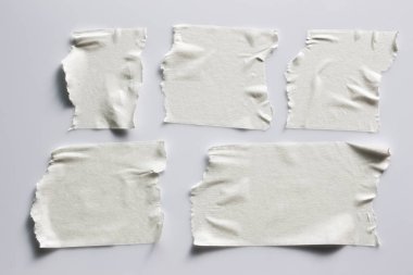 Ve beyaz viski kasetler gri arka plan üzerinde ayarlayın. Yatay ve farklı boyut beyaz yapışkan bant, yapıştırıcı parçaları yırtılmış.