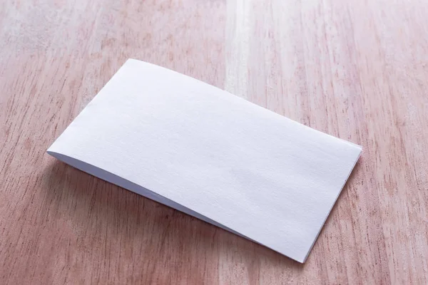 Boş portre mock-up kağıt. Broşür dergi izole kahverengi ahşap masa, değiştirilebilir arka plan / beyaz kağıt ağaç izole