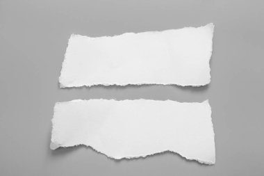 Gri arka planda beyaz yırtık kağıt. koleksiyon kağıdı yırtılması