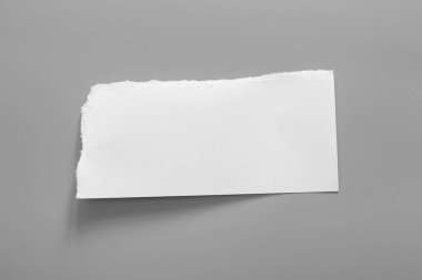 Gri arka planda beyaz yırtık kağıt. koleksiyon kağıdı yırtılması