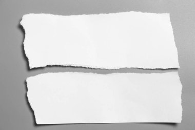 Gri arka planda beyaz yırtık kağıt. koleksiyon kağıdı yırtılması