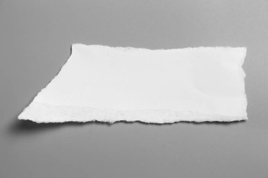 Gri arka planda beyaz yırtık kağıt. koleksiyon kağıdı yırtılması