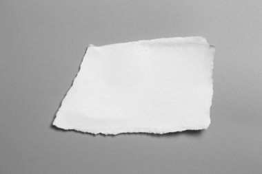 Gri arka planda beyaz yırtık kağıt. koleksiyon kağıdı yırtılması