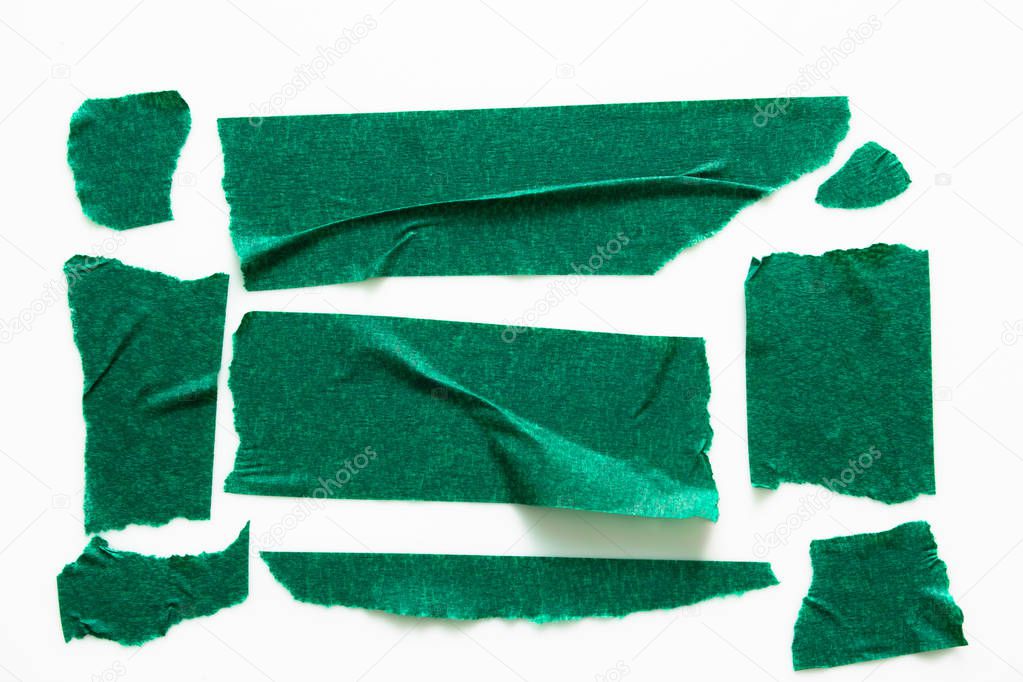 Set of green tapes on white background. Torn horizontal and different size green sticky tape, adhesive pieces.