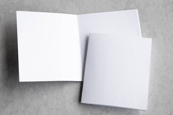 Blank portrait mock-up paper. brochure magazine isolated on gray, changeable background / white paper isolated on gray cement backdrop.