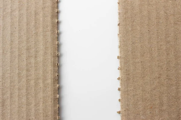 Brown corrugated texture paper torn on white background. rip of cardboard sheet used as a background .
