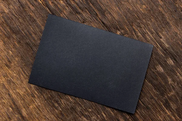 Blank portrait mock-up paper. brochure magazine isolated on brown wooden table, changeable background / Black paper isolated on wood