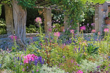 Eski bir taş kemer arka planda çiçek yatağı