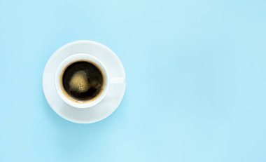 Mavi arka planda fotokopi alanı olan bir fincan kahve. Güne canlı bir başlangıç. Kahvaltı, günaydın. Minimalizm