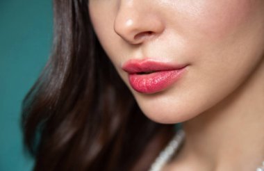 Güzel bir kızın yüzünün alt kısmının yakın plan çekilmiş hali. Parlak dudaklar. Biçimli saç