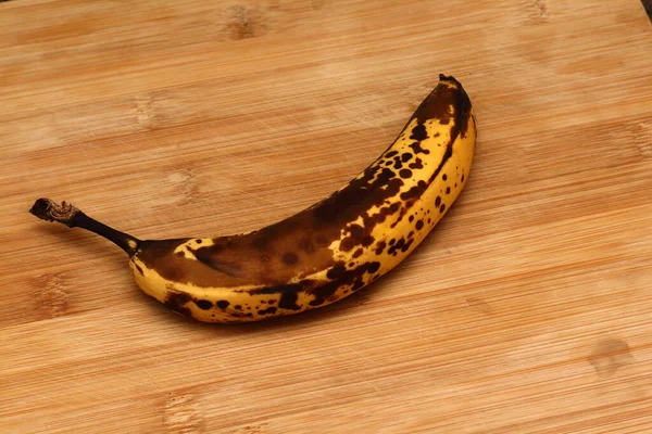 Old banana on wooden board. Ripe yellow bananas on old wooden board.